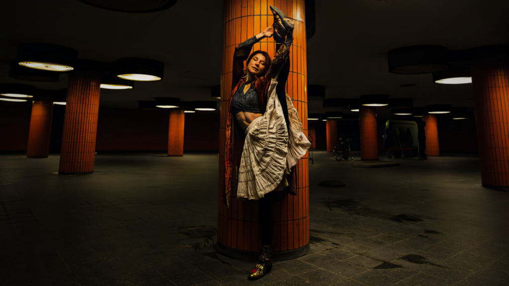 Seraphina Taylor performing an expressive ballet-inspired pose in an underground Berlin station, blending dance, poetry, and urban art.